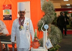 Een trotste Egyptische kok naast zijn kunstwerk in het Hollandpaviljoen.