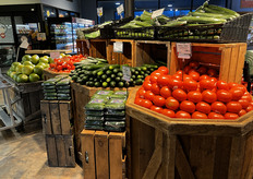 Komkommers en tomaten worden uitgelicht op tafels en kisten