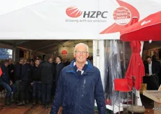 In de regen poseert Douwe Lodewijk voor de grote tent van HZPC Holland bv. Volgens Douwe verliest de beurs door de regen de glans, die het normaal wel heeft.