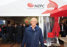 In de regen poseert Douwe Lodewijk voor de grote tent van HZPC Holland bv. Volgens Douwe verliest de beurs door de regen de glans, die het normaal wel heeft.