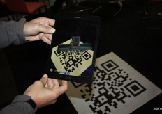 Marcel Oldenziel van Manter International bv toont een machine op de tablet. Door de QR-code op de grond te scannen is de machine op de tablet te zien. De machine op de tablet wordt ingezet om kratten te vullen. Tot op het kleinste schroefje is de krattenvuller te bekijken. Marcel verwacht dat deze vorm van technologie slechts het begin is en dat ook de virtual realitybril in deze sector steeds vaker gebruikt zal worden.