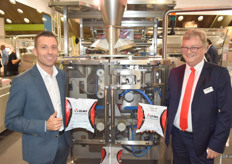 Dominique De Velder en Alex Hofstee van GH-Ulma. Achter hen de VTC 800 die ervoor zorgt dat verpakkingen strakker zijn dan gebruikelijk. Volgens Alex bevatten de tight bags minder lucht, met als gevolg dat er 15 procent meer zakken in een krat passen, waardoor de transportkosten dalen.