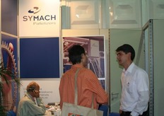 Een bezoeker krijgt informatie bij Symach Palletizers.