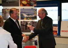 De directeur van STC overhandigt Mooy Logistic directeur Wim Zonnevylle een voorbeeld van hun nieuwe school
