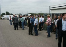 Bouwers, genodigden en medewerkers staan te wachten op wat komen gaat.