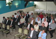 De aanwezigen luisteren aandachtig naar wat de voorzitter te vertellen heeft.