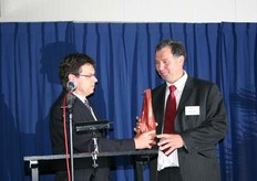 Jan Janssen ontvangt fles als symbolische overdracht pand.