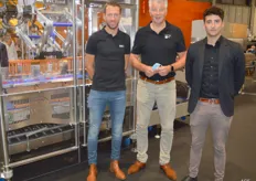 Jasper Slaghekke en Gerrit Tijhof van Sismatec met Charlie Hook van ProSeal UK poserend voor de casepacker die getopsealde verpakkingen volautomatisch in een omdoos kan positioneren.