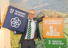 Michaël Wilde van Eosta tussen een aantal VN ontwikkelingsdoelen, welke door Eosta worden omarmd.