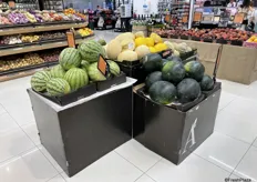 De meloenen staan op een display in het midden van de supermarkt.